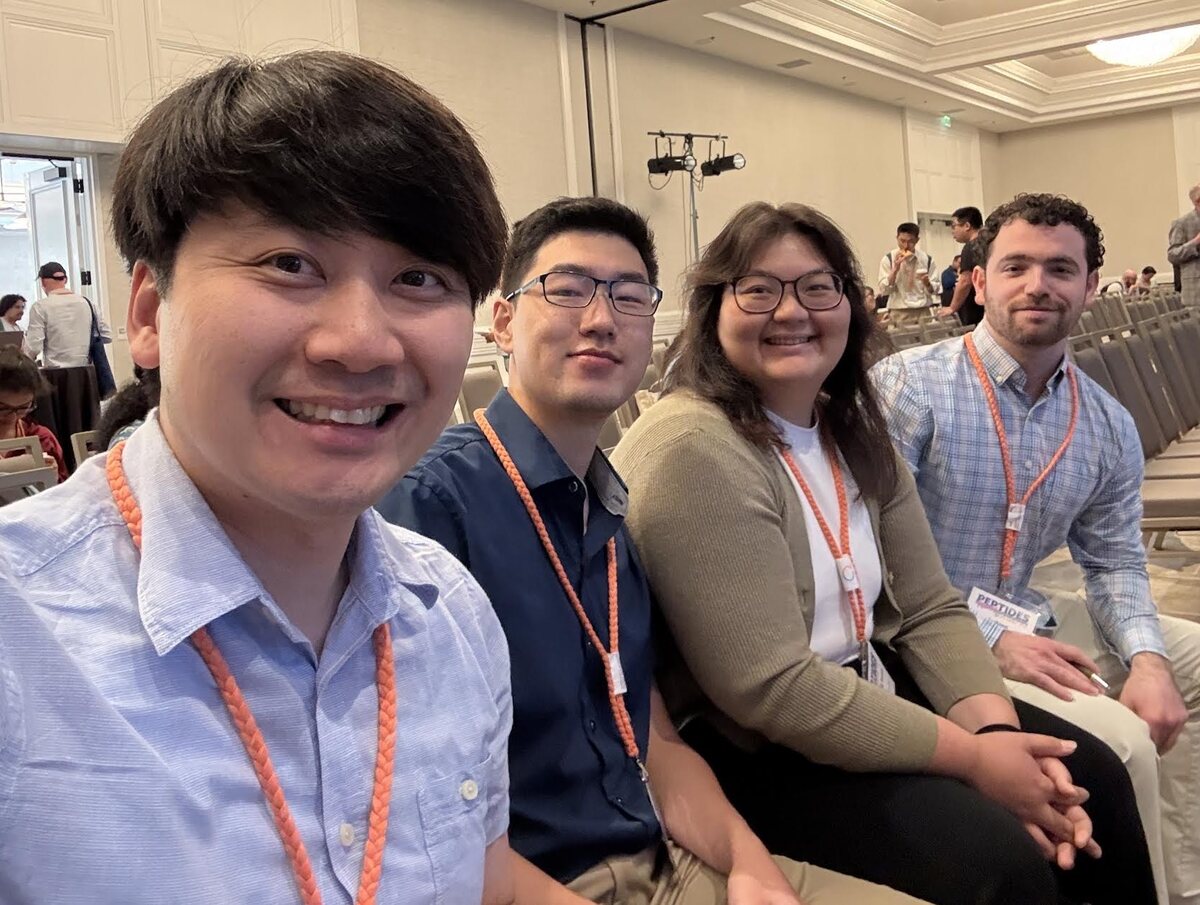 Four Nowick group members and alumni seated together in a lecture hall at the American Peptide Symposium.